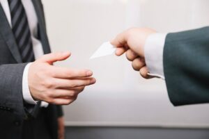 Small business owner exchanging business cards with an accountant at a networking event.